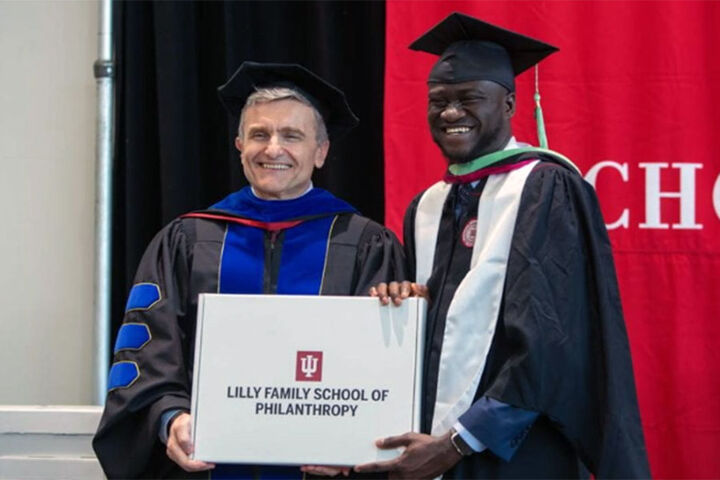 A graduate stands with the dean of the Lilly Family School of Philanthropy.